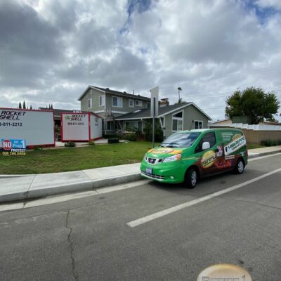 Repipe1 service van parked in front of a house with Rocket Shell containers nearby.