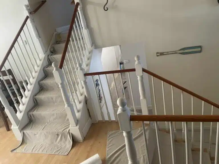 Staircase with protective coverings on the steps, indicating renovation work.